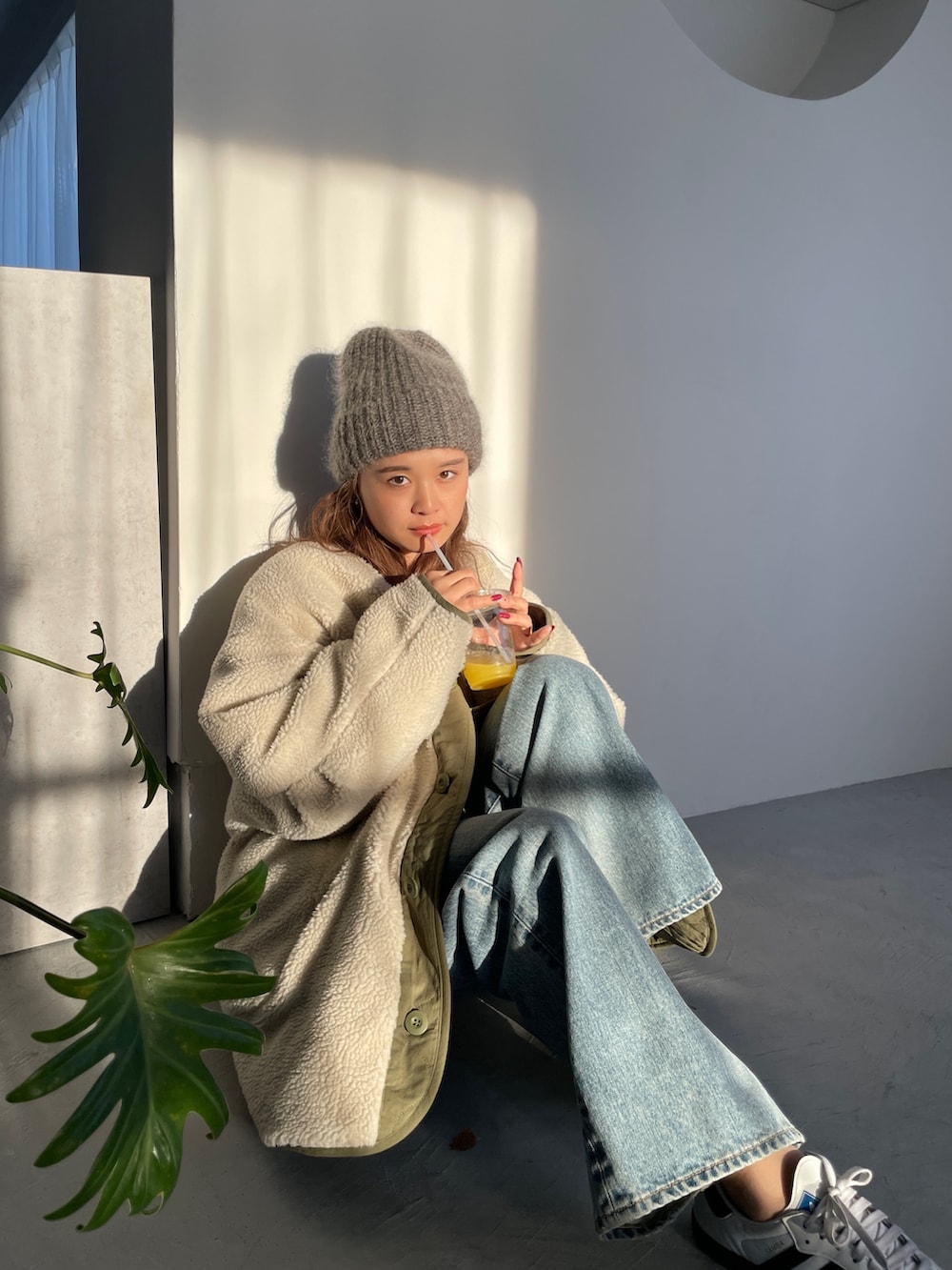 ホワイト系のブルゾン、ブルー系のデニムパンツを着用したレディースの冬コーディネートの4枚目の写真