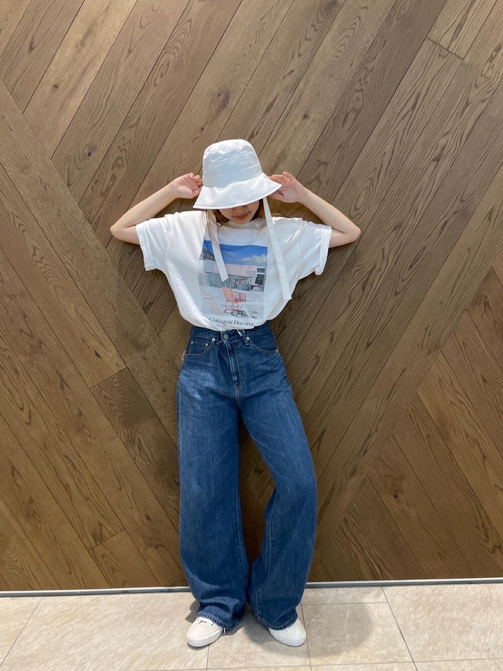 ブルー系のデニムパンツ、ホワイト系のスニーカー、グレー系のTシャツ/カットソーを着用したレディースの春コーディネートの3枚目の写真