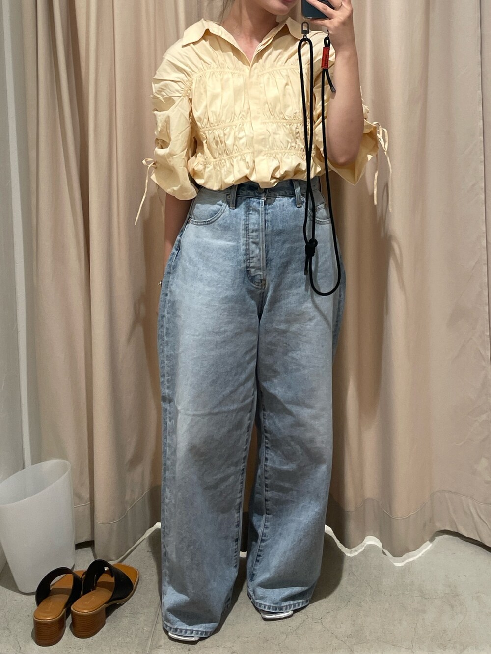ブルー系のデニムパンツ、シルバー系のサンダル、イエロー系のシャツ/ブラウスを着用したレディースの夏コーディネートの3枚目の写真