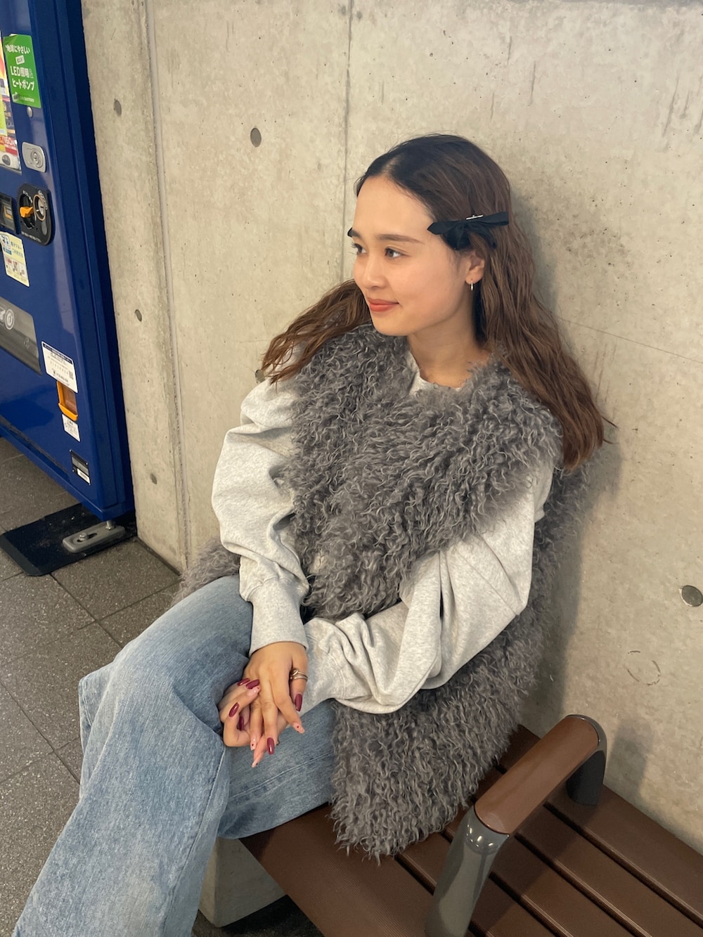 ブルー系のデニムパンツ、グレー系のスウェット、グレー系のベストを着用したレディースの冬コーディネートの8枚目の写真