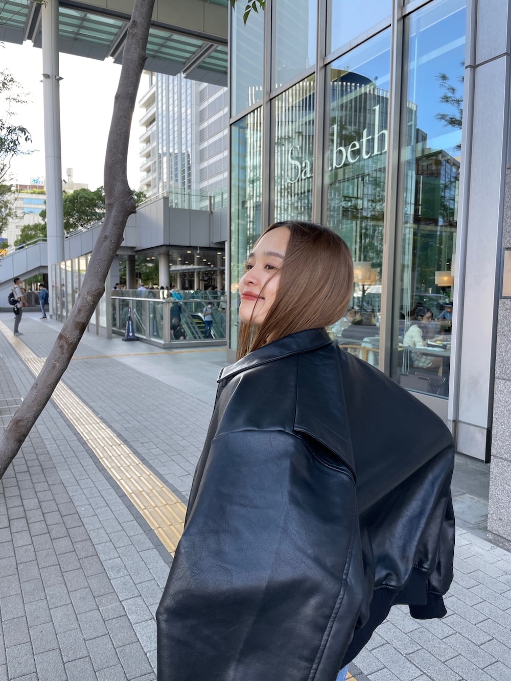 ブラック系のブルゾン、ブルー系のニット/セーター、ブルー系のデニムパンツを着用したレディースの秋コーディネートの2枚目の写真