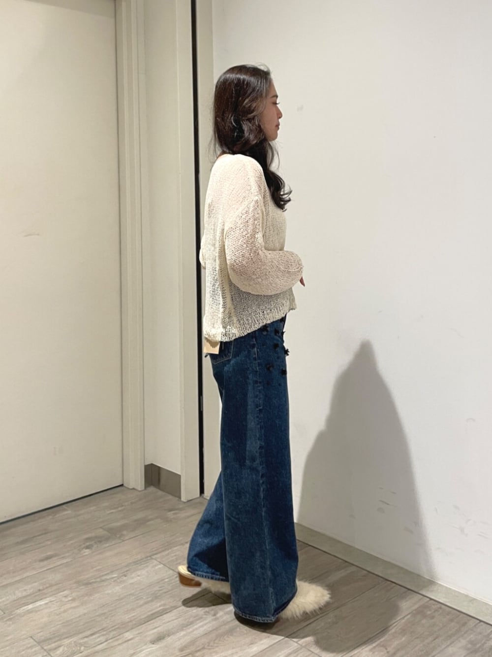 ホワイト系のニット/セーター、ホワイト系のその他シューズ、ブルー系のデニムパンツを着用したレディースの夏コーディネートの4枚目の写真