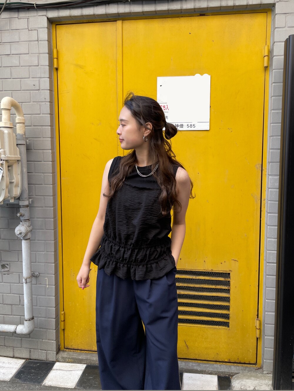 ブラック系のタンクトップ、ブルー系のその他パンツを着用したレディースの春コーディネートの2枚目の写真