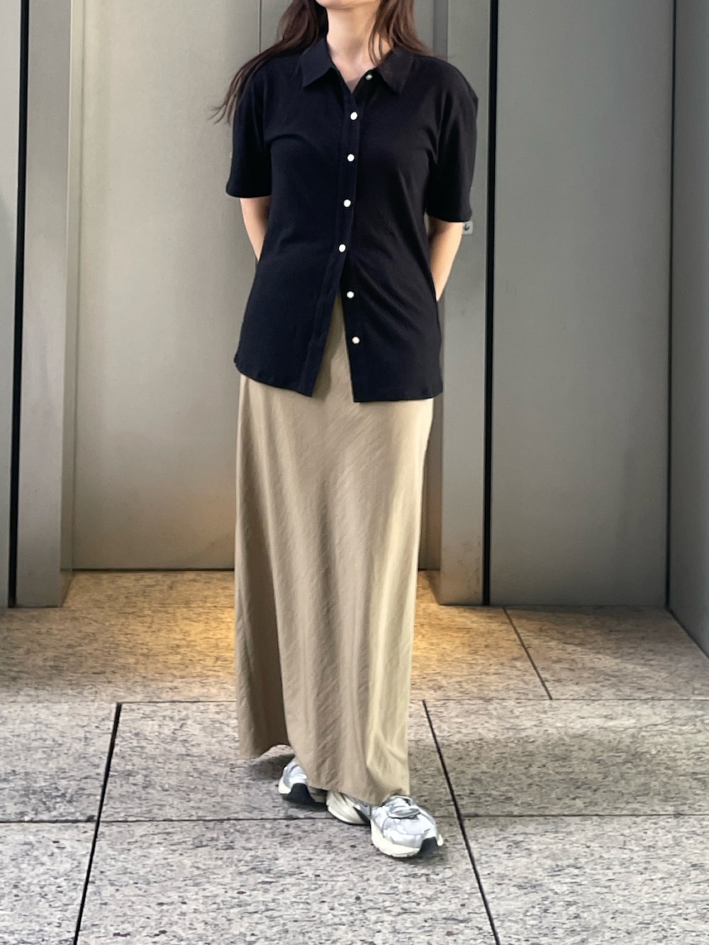 ブラック系のカーディガン/ボレロ、ベージュ系のスカートを着用したレディースの夏コーディネートの2枚目の写真