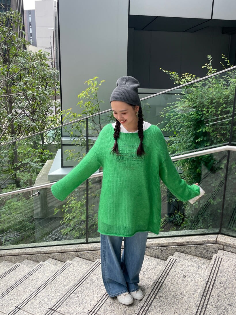 ブルー系のデニムパンツ、ホワイト系のTシャツ/カットソー、グリーン系のニット/セーターを着用したレディースの秋コーディネートの4枚目の写真