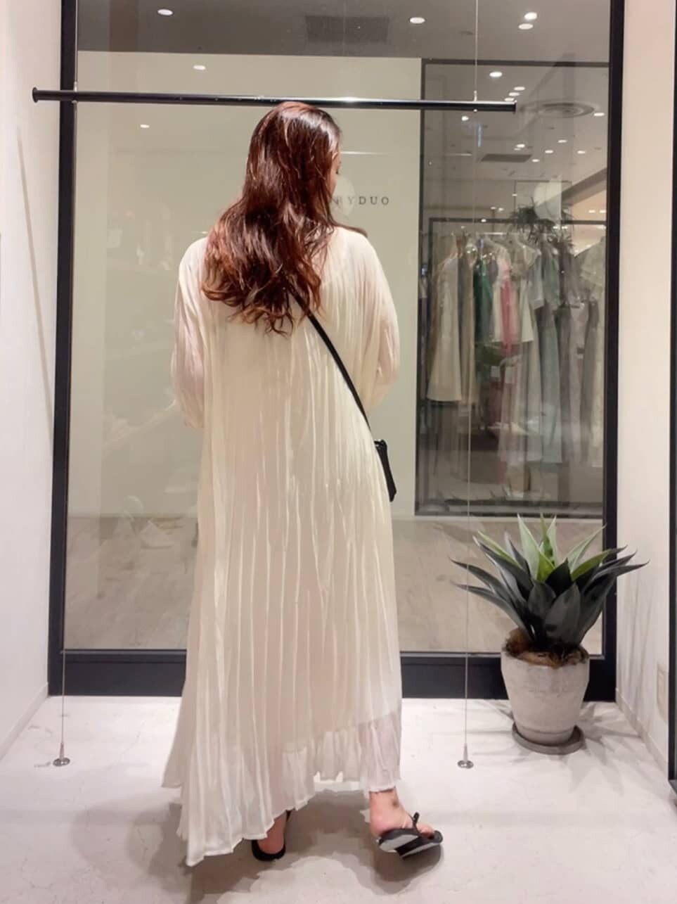 ホワイト系のワンピース、ブラック系のショルダーバッグ、ブラック系のサンダルを着用したレディースの夏コーディネートの3枚目の写真