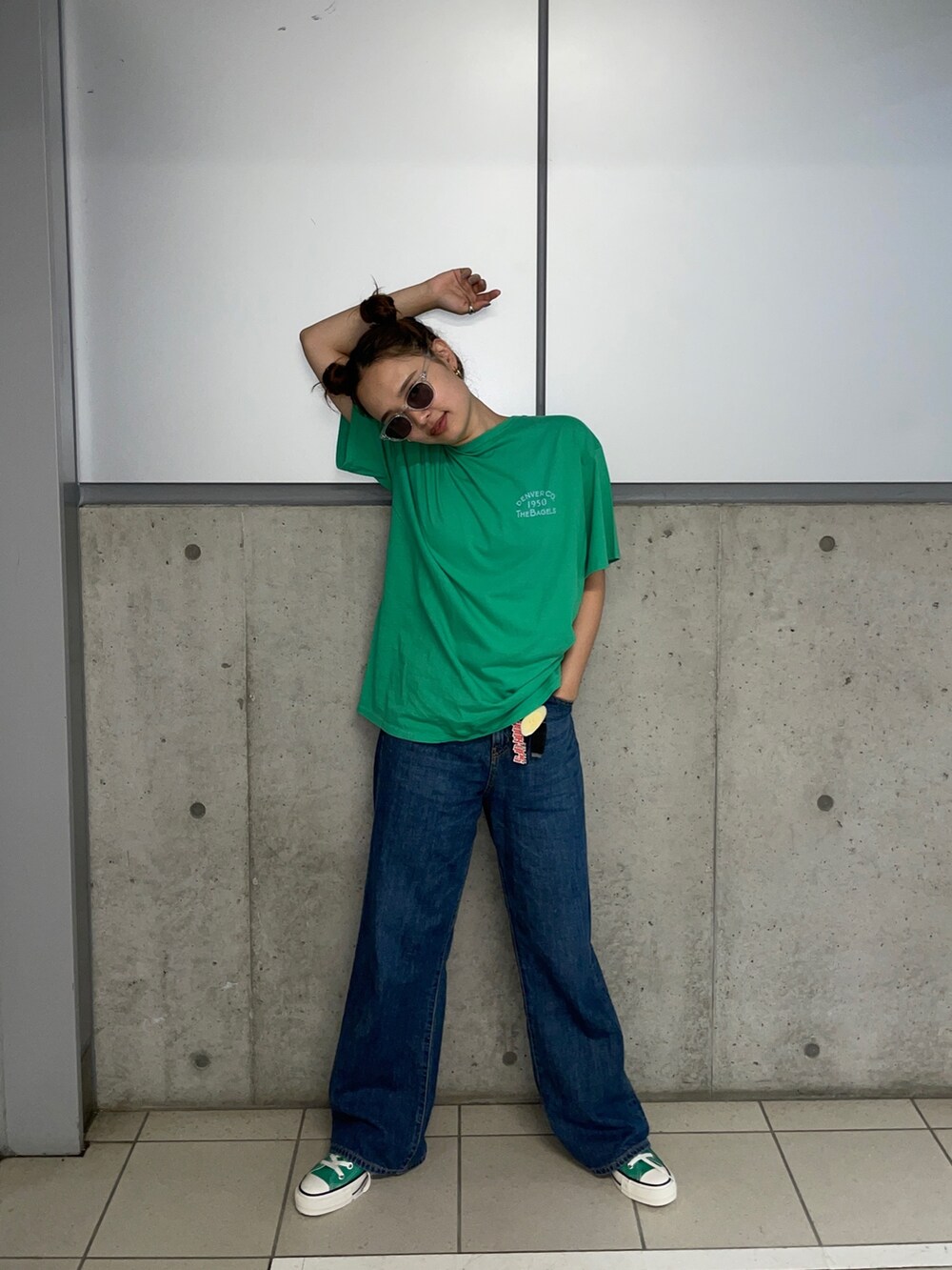 ブルー系のデニムパンツ、オレンジ系のTシャツ/カットソーを着用したレディースの夏コーディネートの2枚目の写真