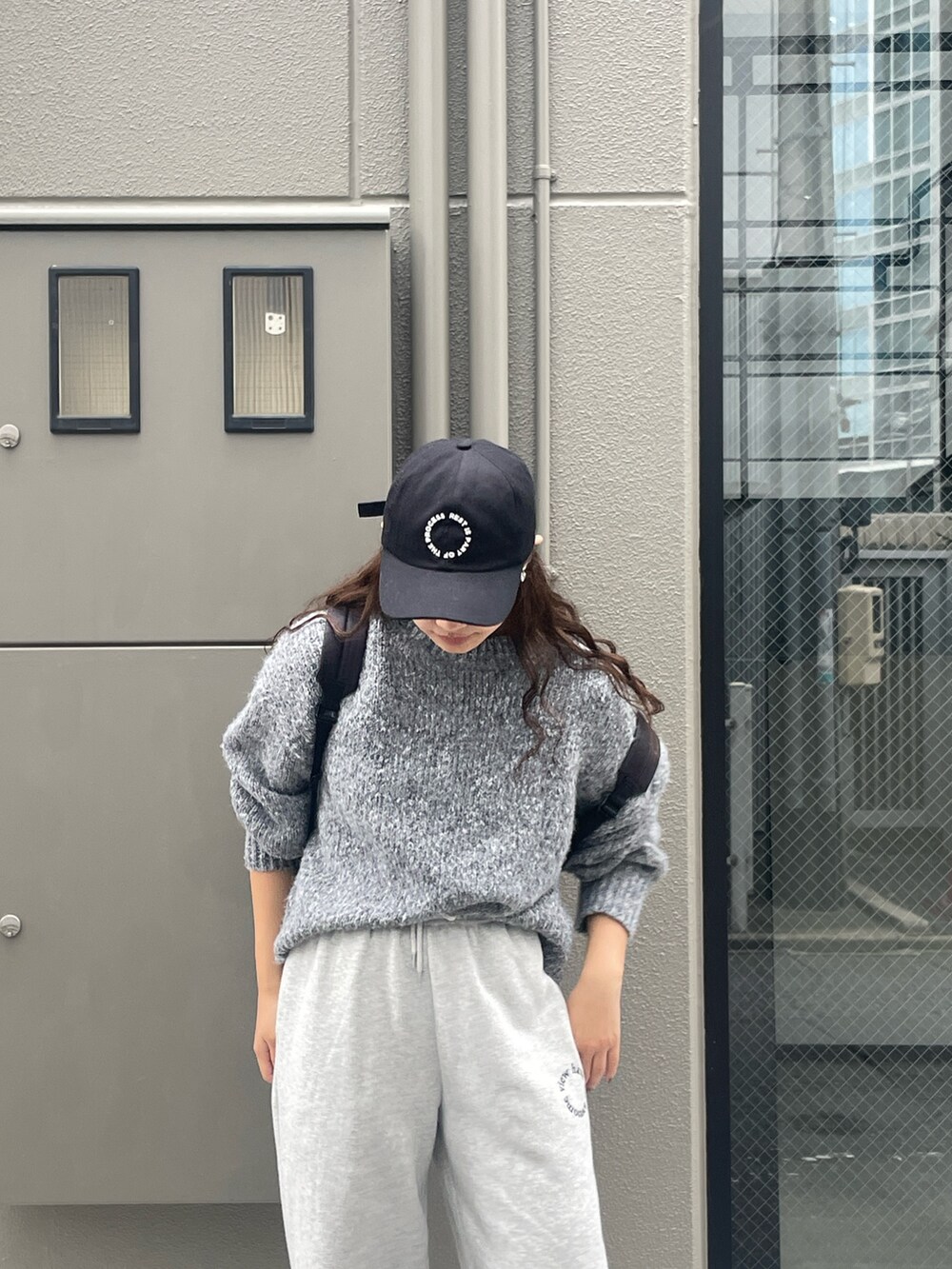 グレー系のスウェットパンツ、グレー系のニット/セーター、ブラック系のキャップを着用したレディースの秋コーディネートの4枚目の写真