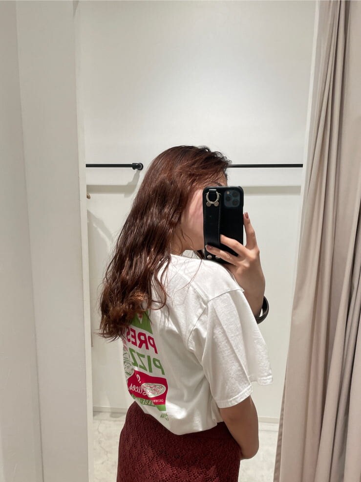 ホワイト系のTシャツ/カットソー、オレンジ系のスカート、ブラウン系のブレスレットを着用したレディースの春コーディネートの5枚目の写真