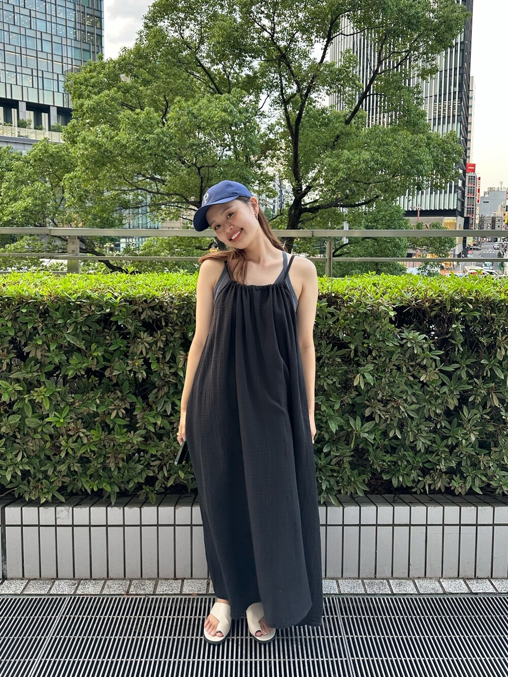 ブラック系のワンピース、ホワイト系のキャップを着用したレディースの夏コーディネートの4枚目の写真