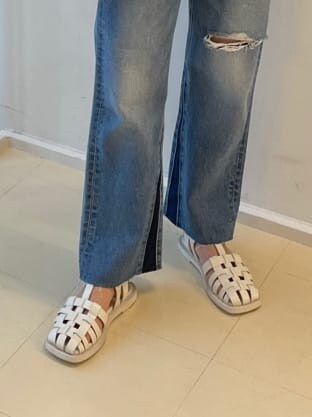 ホワイト系のサンダル、ブルー系のデニムパンツ、ホワイト系のショルダーバッグを着用したレディースの春コーディネートの6枚目の写真