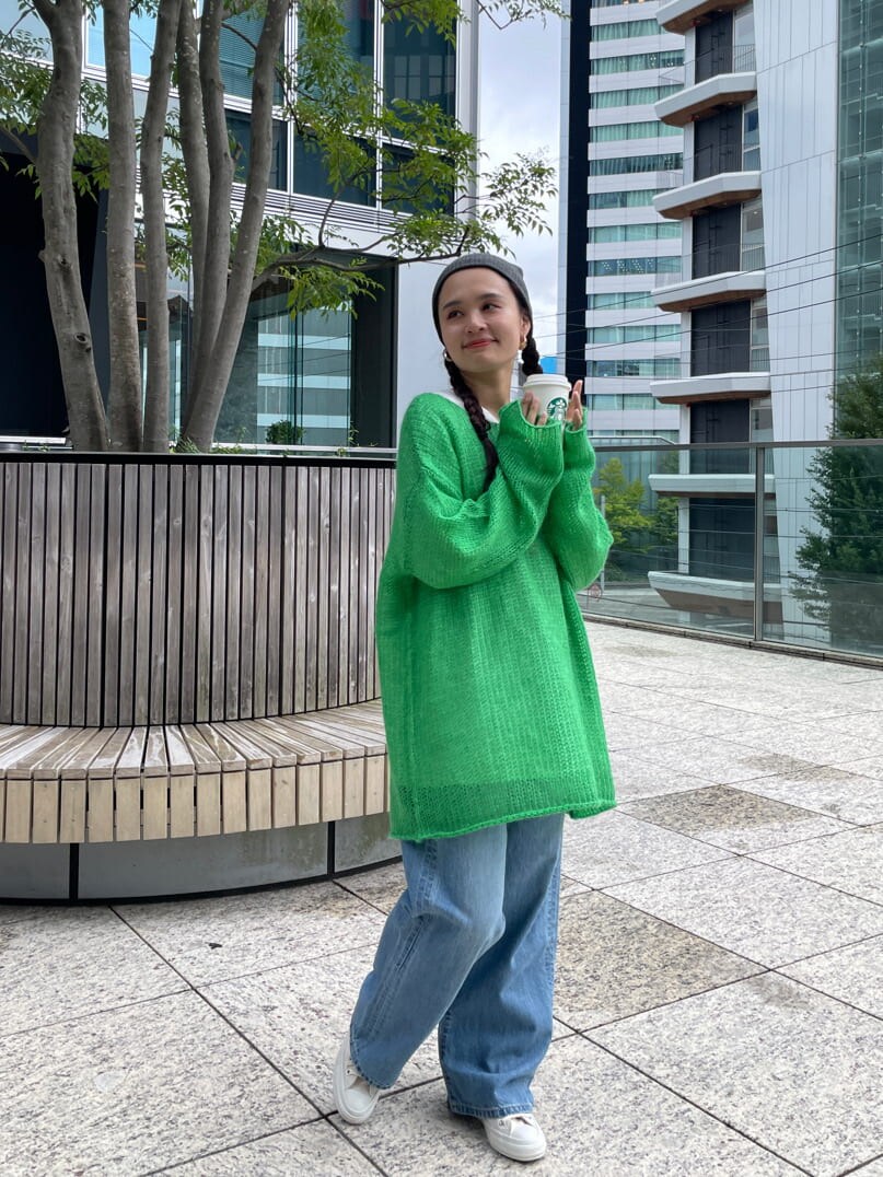 ブルー系のデニムパンツ、ホワイト系のTシャツ/カットソー、グリーン系のニット/セーターを着用したレディースの秋コーディネートの6枚目の写真