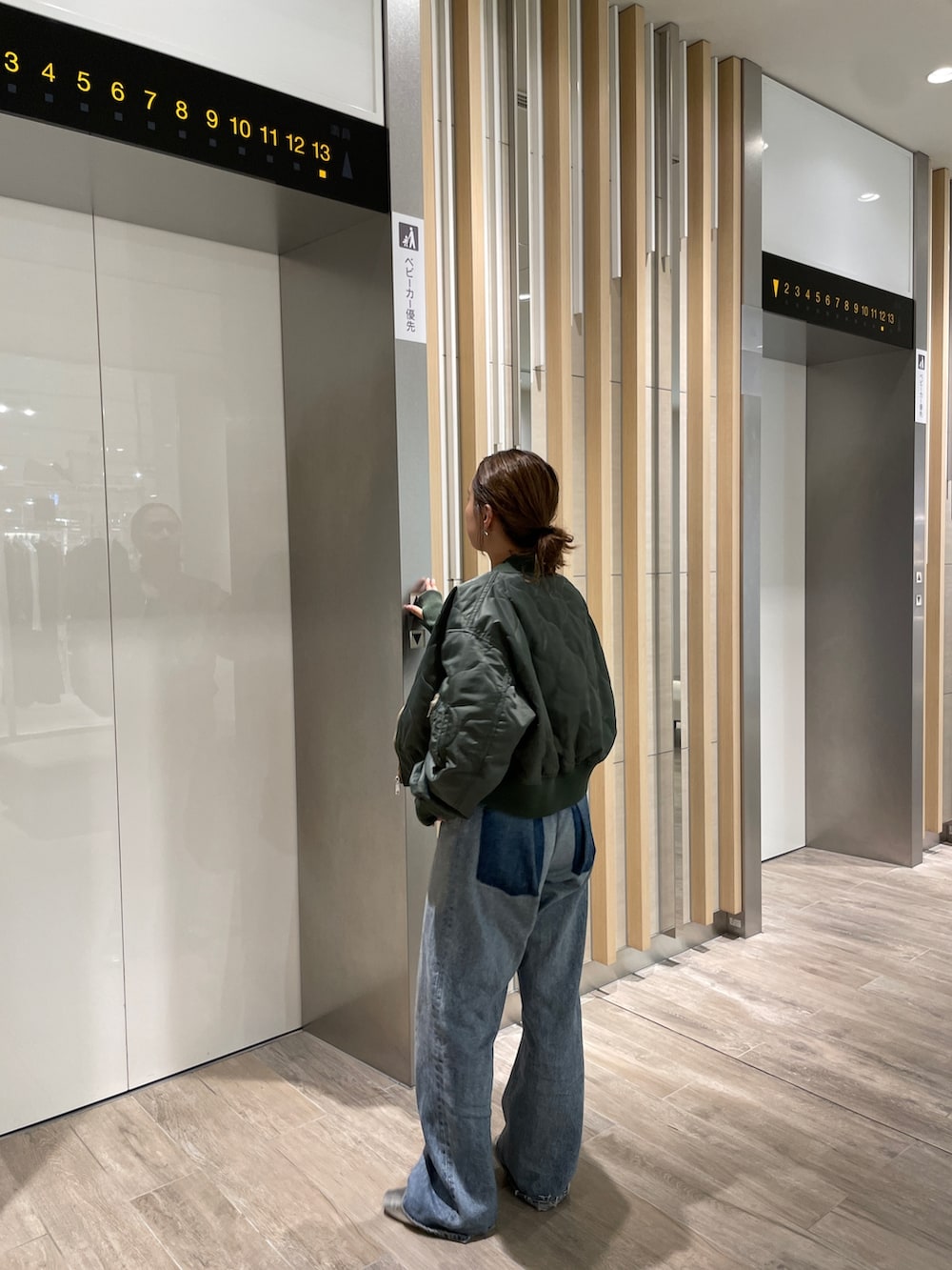 ブルー系のデニムパンツ、シルバー系のパンプス、ベージュ系のブルゾンを着用したレディースの秋コーディネートの5枚目の写真