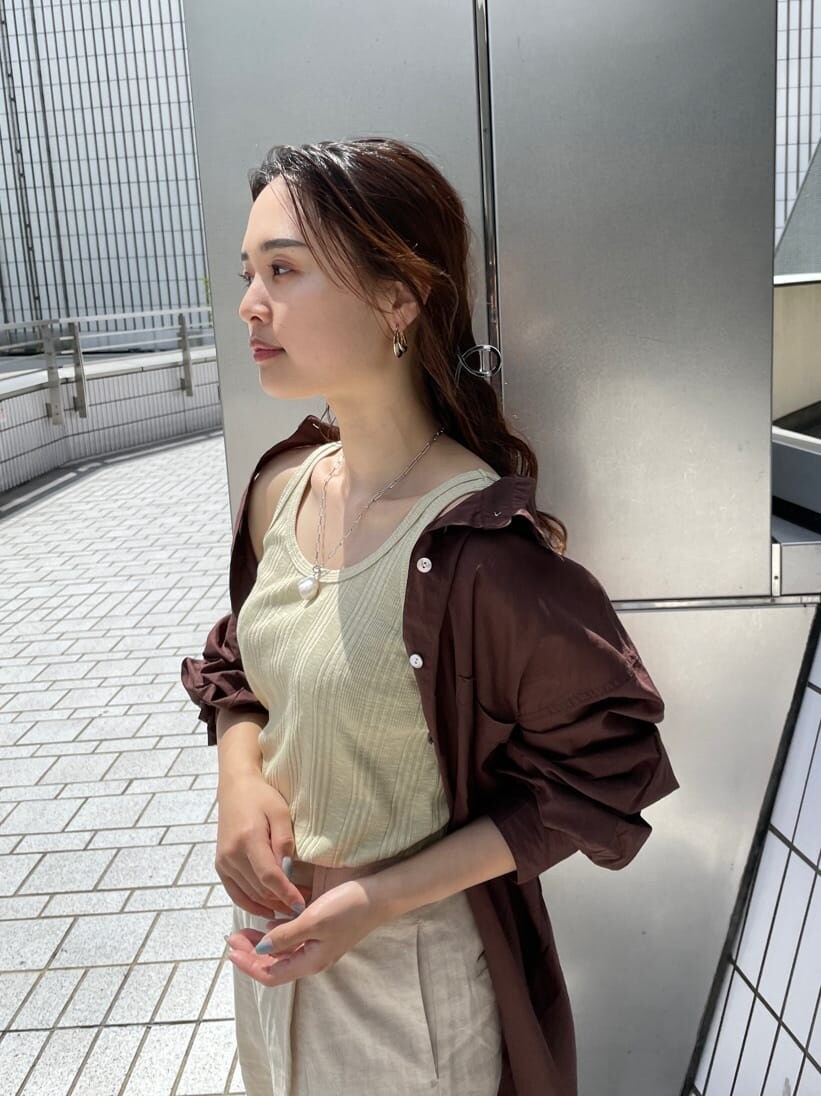 グリーン系のタンクトップ、ブラック系のサンダル、ホワイト系のその他パンツを着用したレディースの夏コーディネートの4枚目の写真