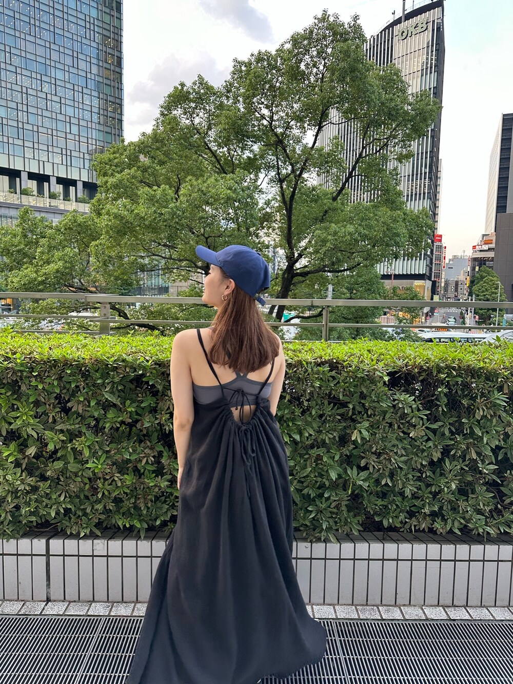 ブラック系のワンピース、ホワイト系のキャップを着用したレディースの夏コーディネートの3枚目の写真