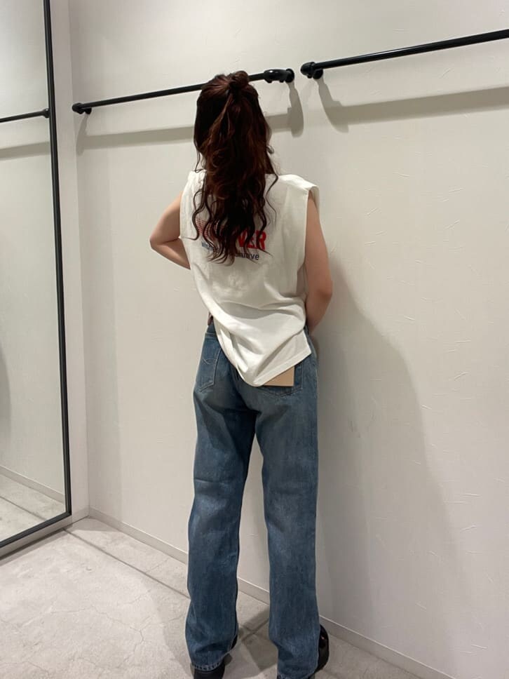 ホワイト系のタンクトップ、ブルー系のデニムパンツ、シルバー系のブレスレットを着用したレディースの春コーディネートの3枚目の写真