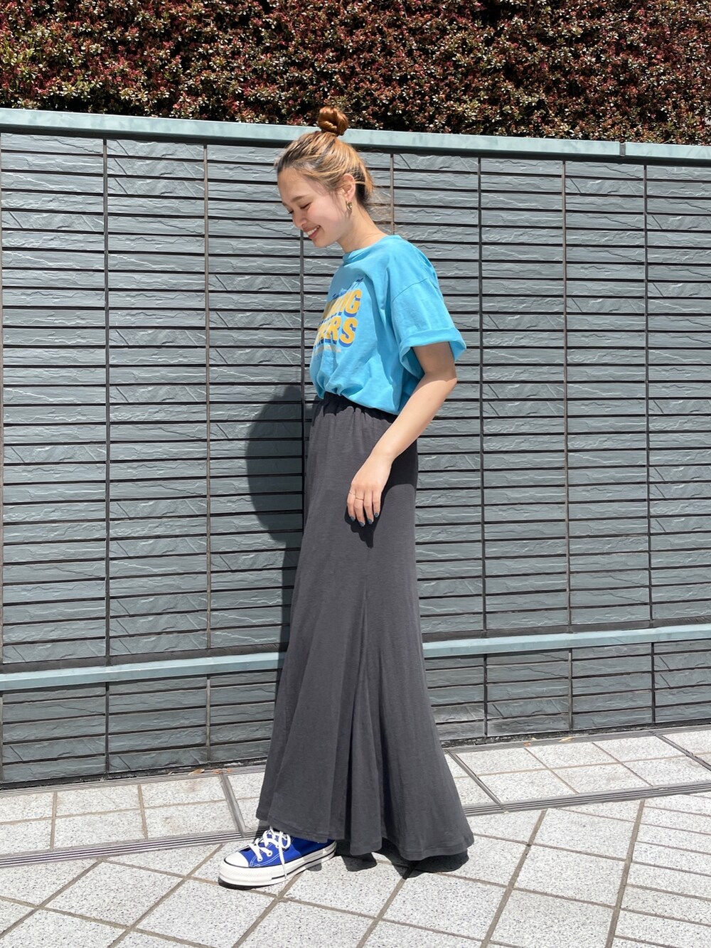 ブルー系のTシャツ/カットソー、グレー系のスカート、ブルー系のスニーカーを着用したレディースの春コーディネートの2枚目の写真