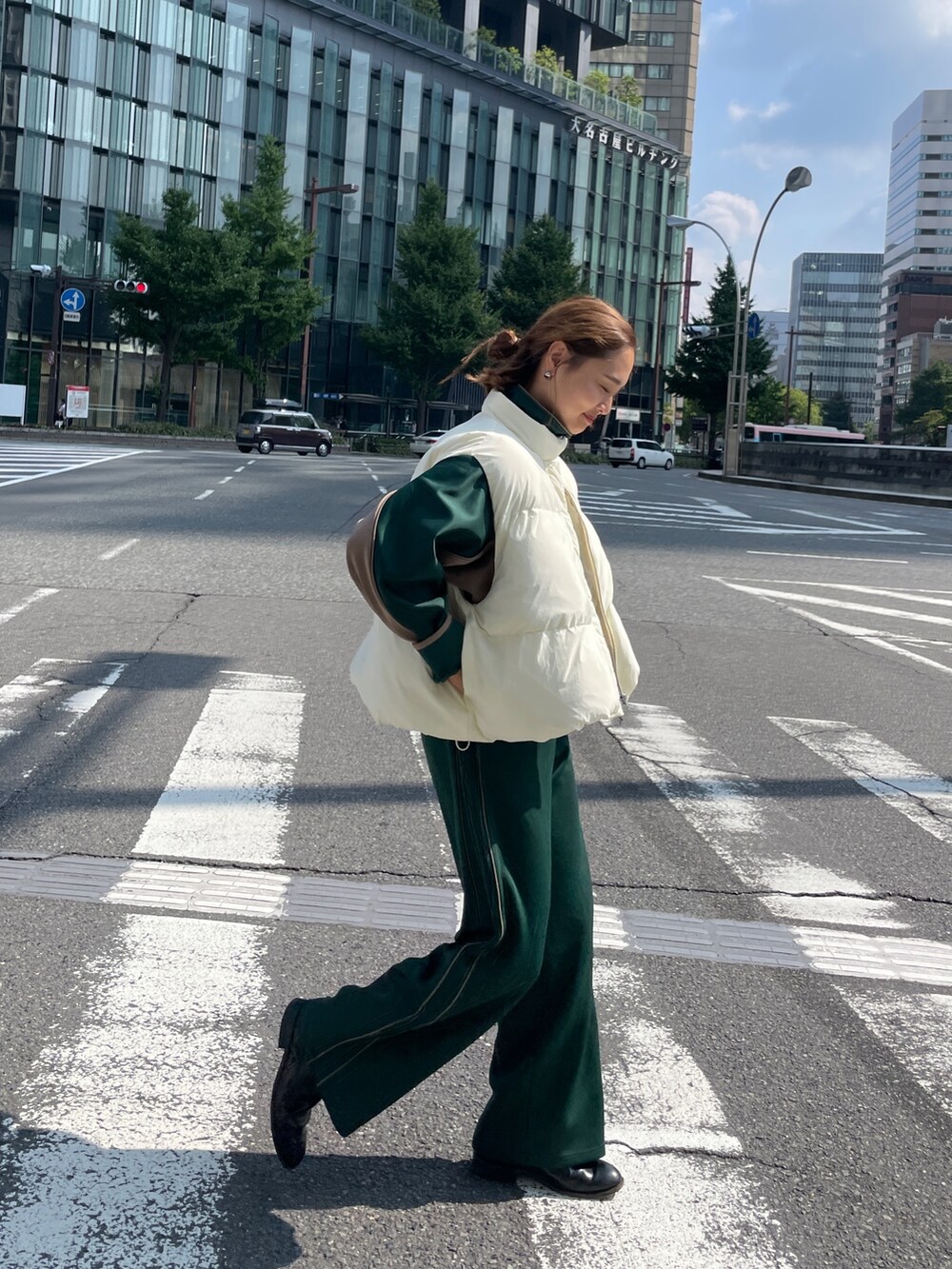 グリーン系のブルゾン、グリーン系のその他パンツ、ホワイト系のダウンベストを着用したレディースの秋コーディネートの5枚目の写真