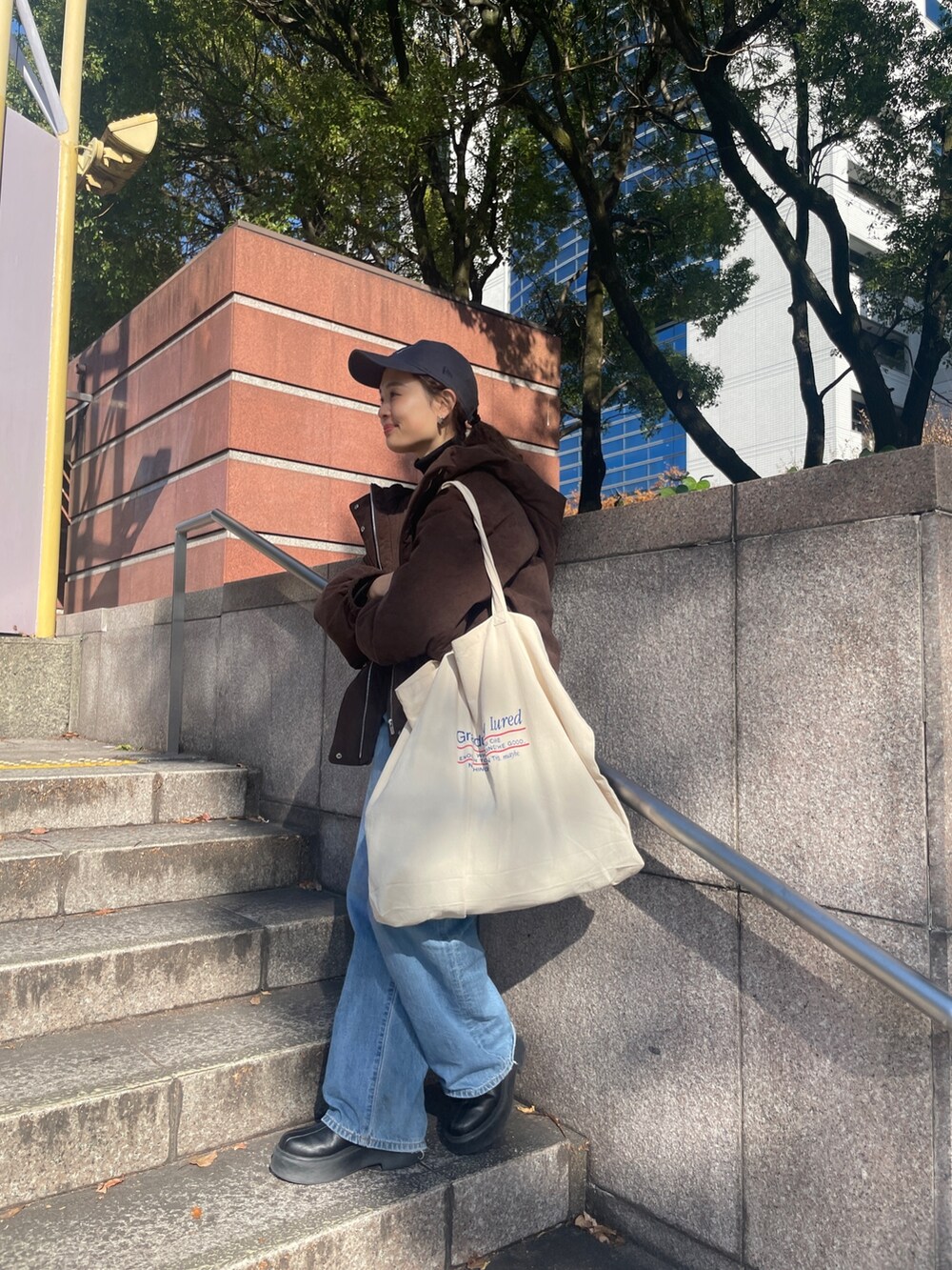 ブルー系のデニムパンツ、ブラウン系のブルゾン、ブラック系のニット/セーターを着用したレディースの冬コーディネートの4枚目の写真