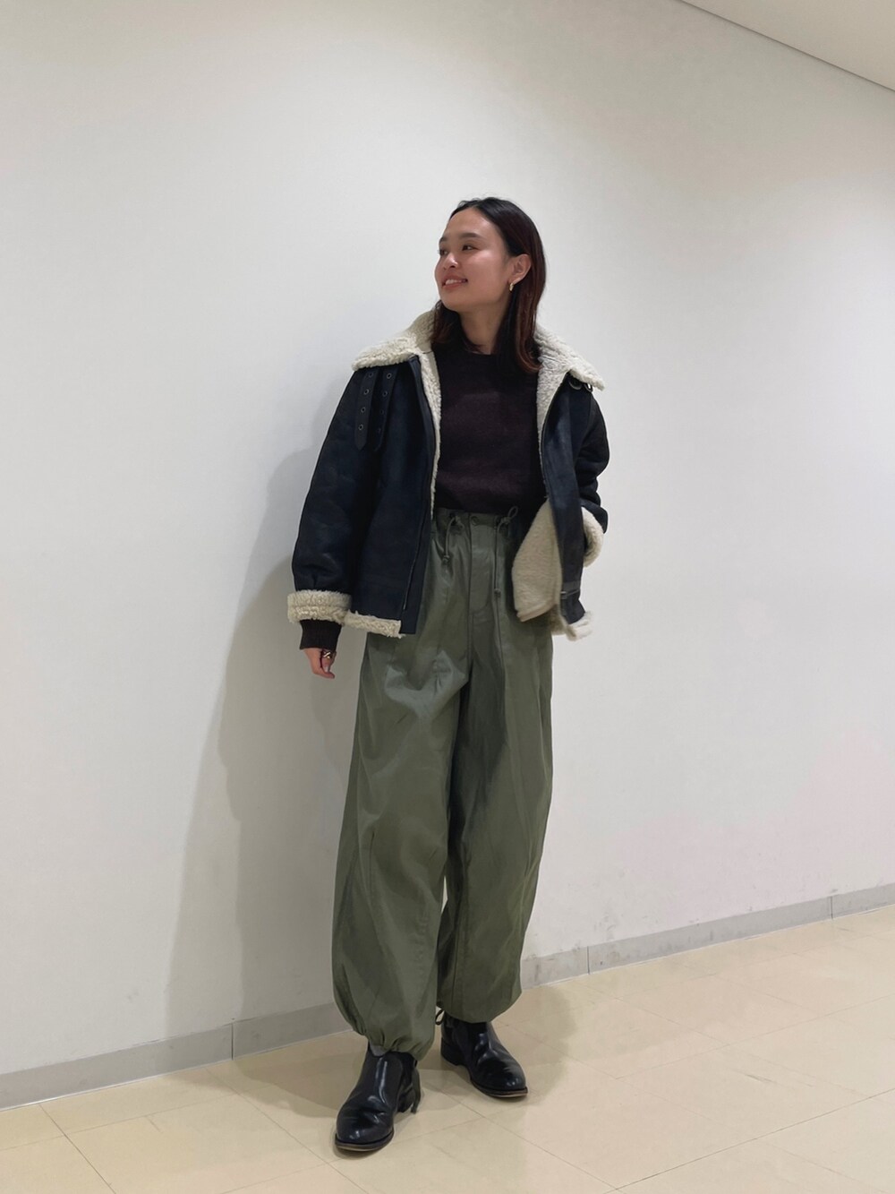 ブラウン系のムートンコート、パープル系のニット/セーター、ベージュ系のその他パンツを着用したレディースの冬コーディネートの4枚目の写真