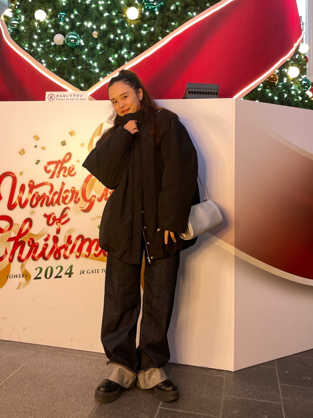 ブルー系のデニムパンツ、ブラック系のブルゾンを着用したレディースの冬コーディネートの2枚目の写真