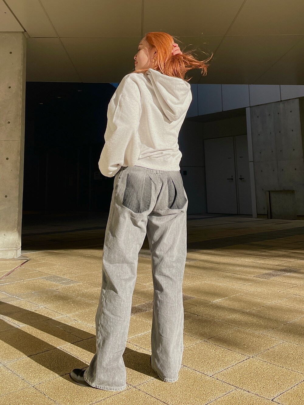 ブラック系のデニムパンツ、グレー系のパーカーを着用したレディースの冬コーディネートの2枚目の写真