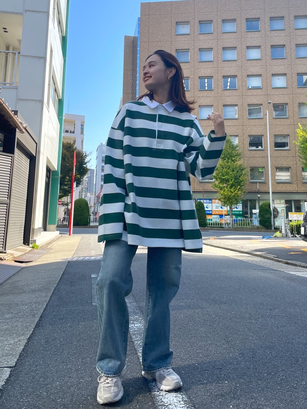 グリーン系のTシャツ/カットソー、ブルー系のデニムパンツを着用したレディースの秋コーディネートの7枚目の写真
