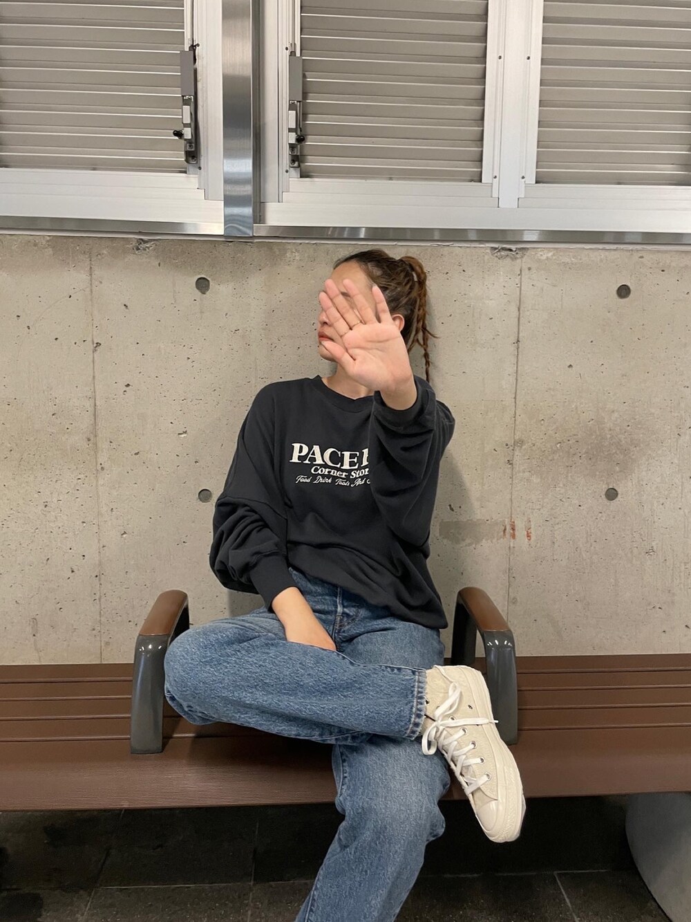 グレー系のスウェット、ブルー系のデニムパンツ、ホワイト系のスニーカーを着用したレディースの夏コーディネートの2枚目の写真