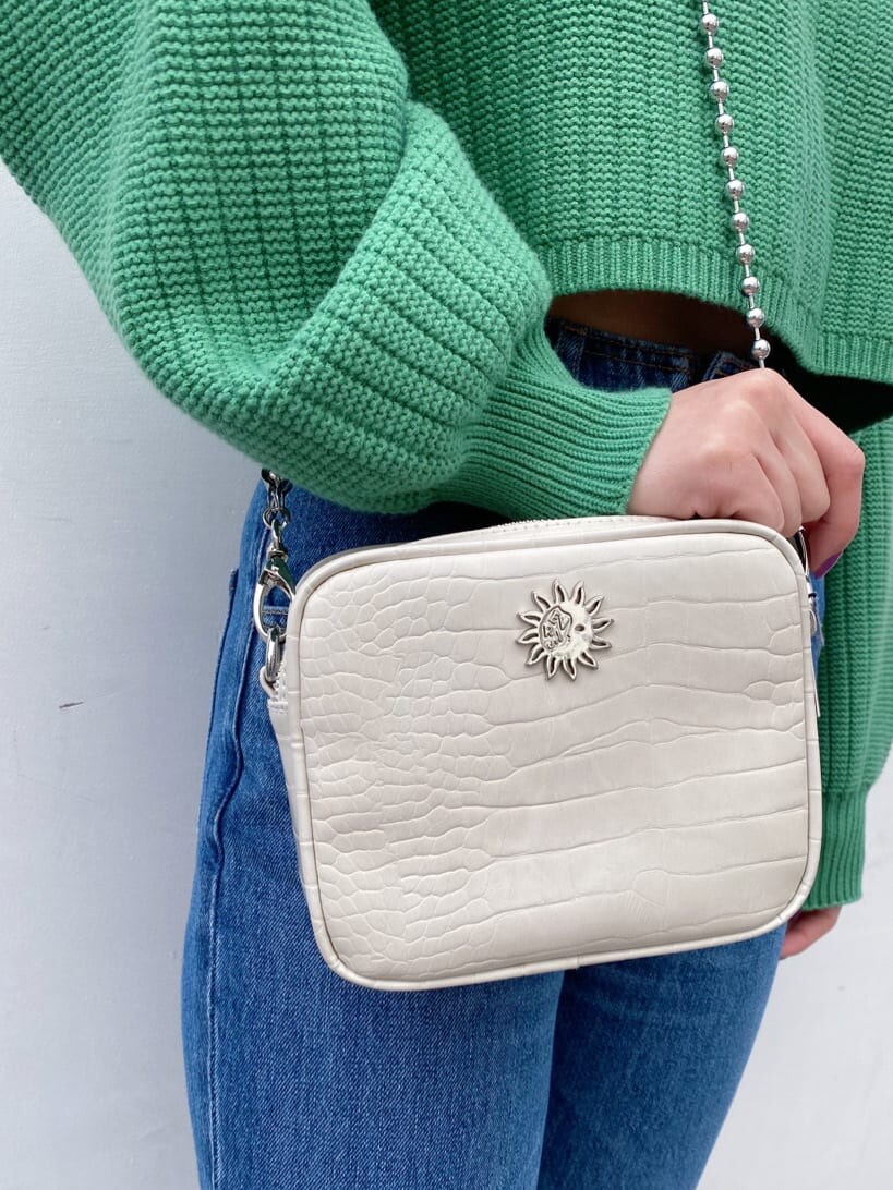 ブラック系のブーツ、ホワイト系のショルダーバッグ、グリーン系のニット/セーターを着用したレディースの冬コーディネートの9枚目の写真