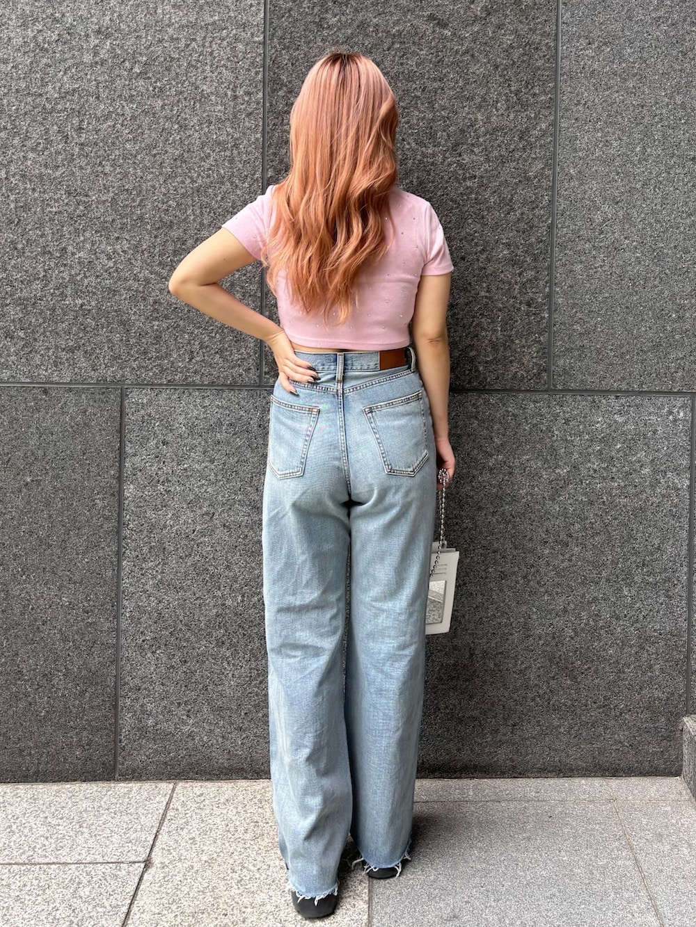 ピンク系のTシャツ/カットソー、ホワイト系のショルダーバッグ、ブルー系のデニムパンツを着用したレディースの春コーディネートの2枚目の写真