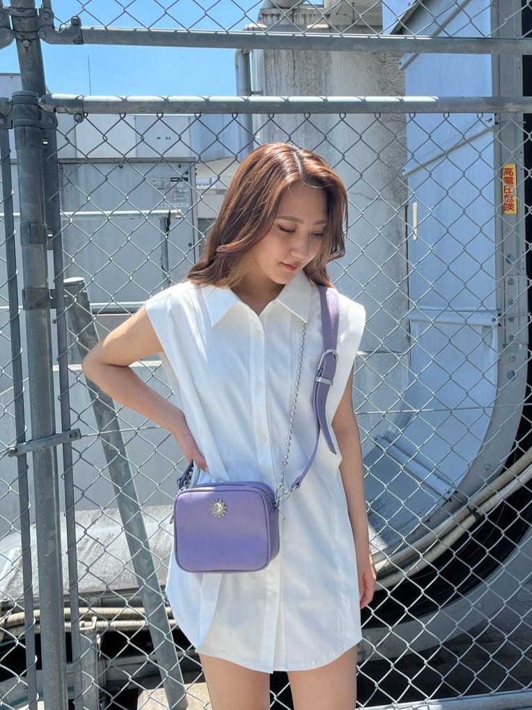 ブラック系のデニムパンツ、ホワイト系のシャツ/ブラウス、パープル系のショルダーバッグを着用したレディースの夏コーディネートの4枚目の写真