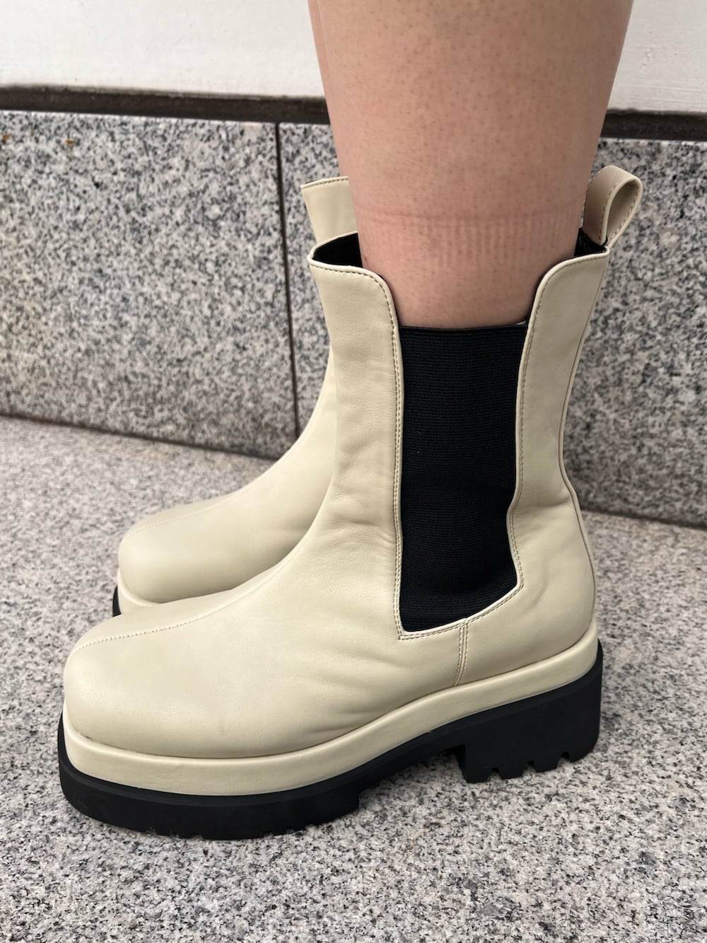 ホワイト系のニット/セーター、ブルー系のデニムスカート、ブラック系のボストンバッグを着用したレディースの冬コーディネートの6枚目の写真