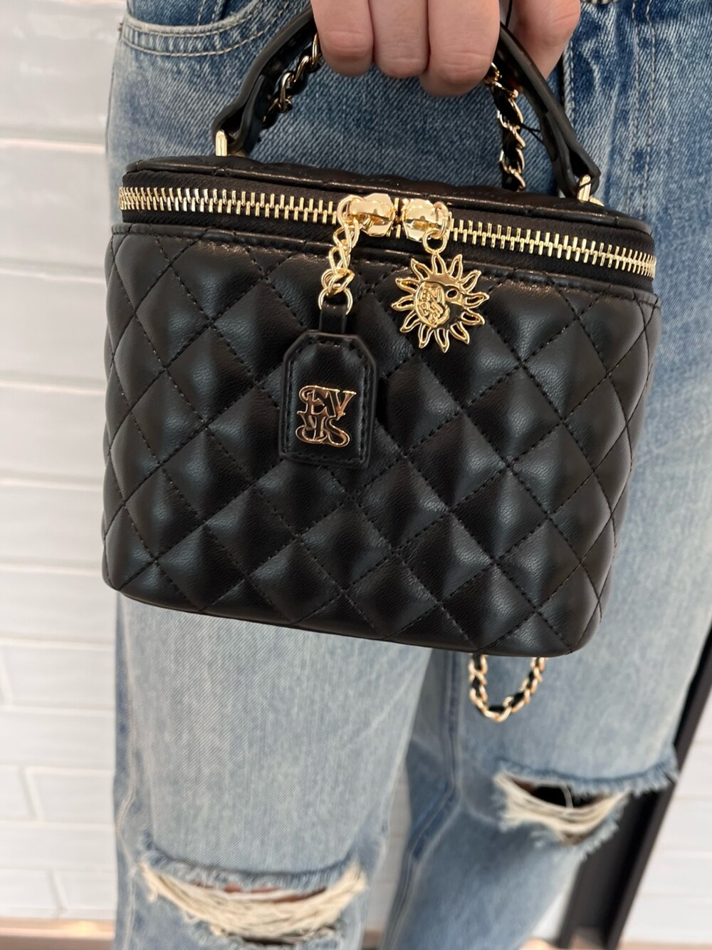 ブラック系のムートンコート、ブルー系のニット/セーター、ブルー系のデニムパンツを着用したレディースの夏コーディネートの8枚目の写真