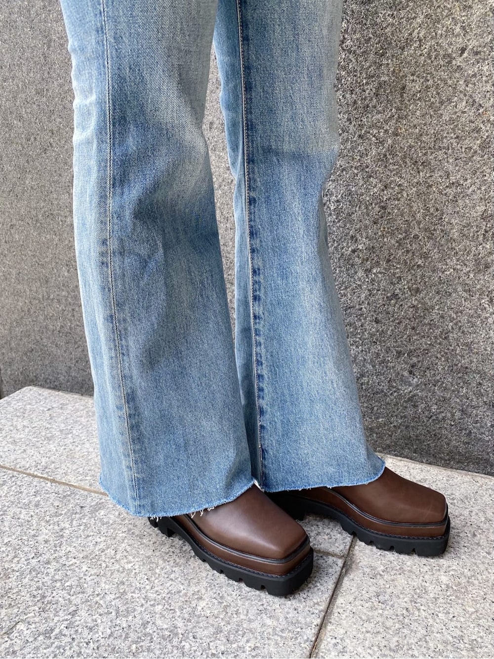 ブルー系のデニムパンツ、ブラウン系のスマホケース/カバー、ブラウン系のベルトを着用したレディースの秋コーディネートの6枚目の写真