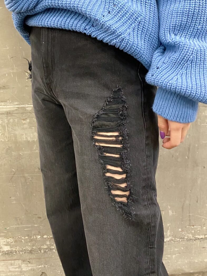 ブラック系のデニムパンツ、ブルー系のニット/セーター、ブラック系のブーツを着用したレディースの冬コーディネートの5枚目の写真