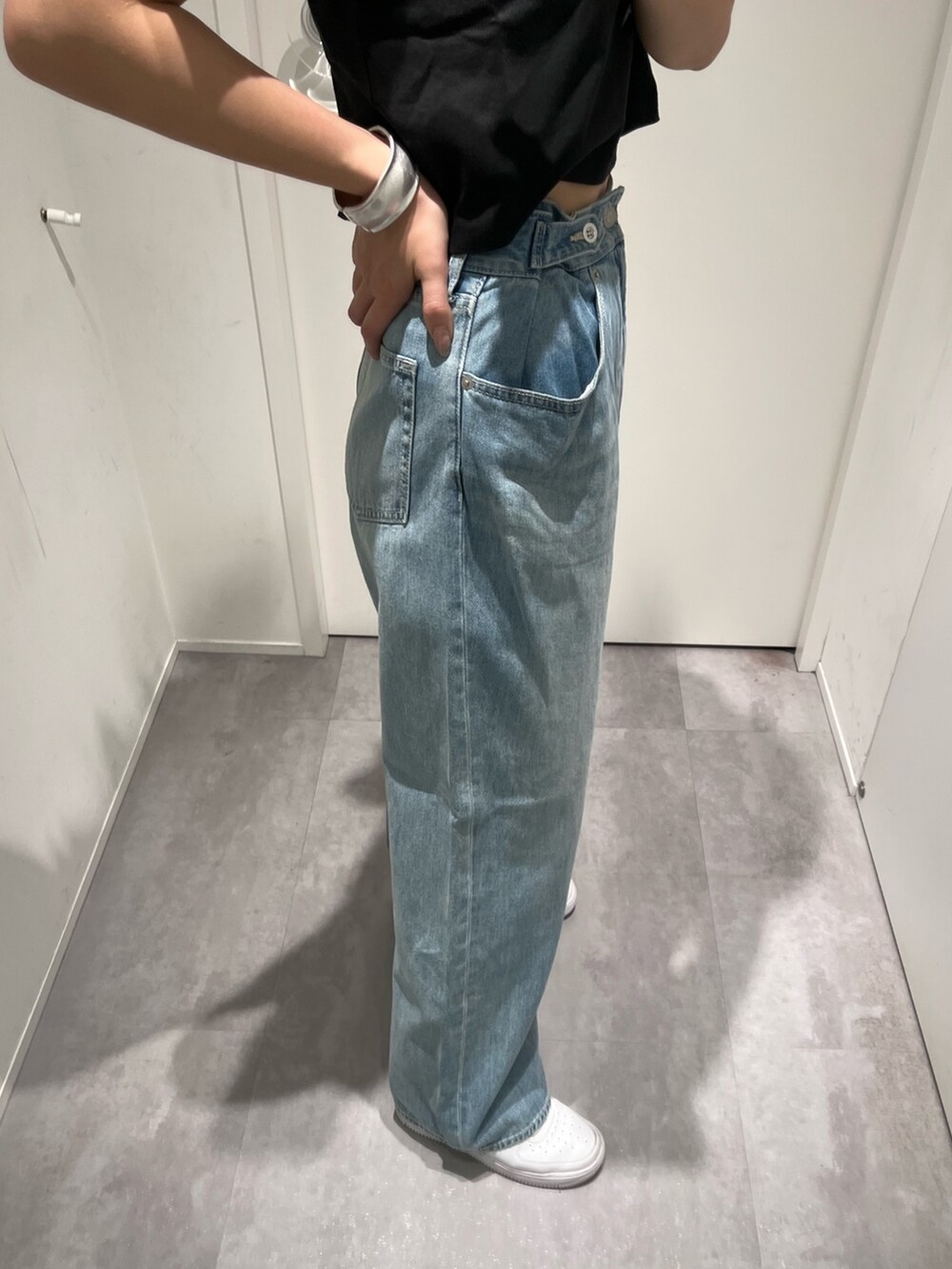 ブラック系のTシャツ/カットソー、ブルー系のデニムパンツ、ブラック系のショルダーバッグを着用したレディースの春コーディネートの6枚目の写真