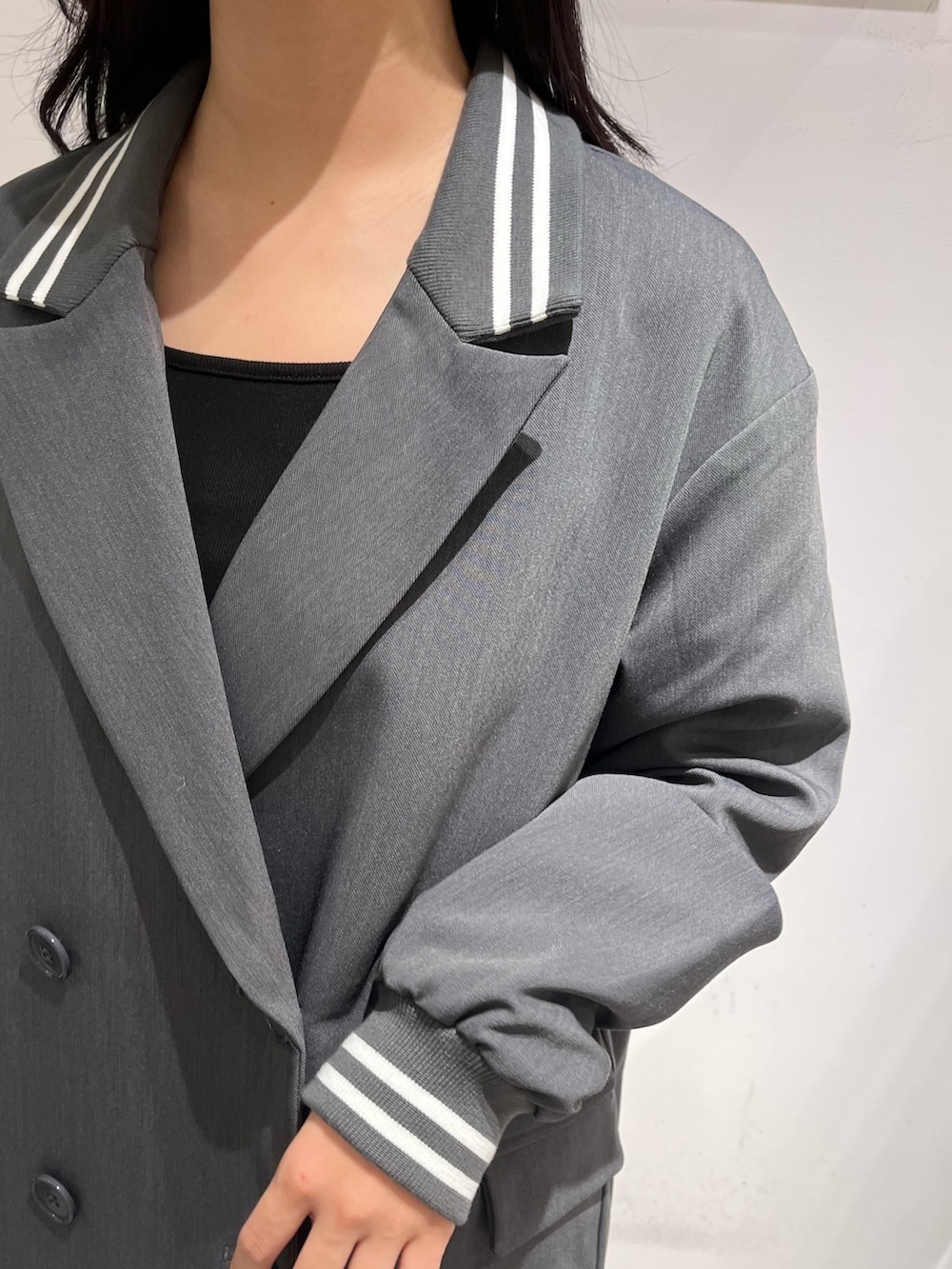 グレー系のテーラードジャケット、ブラック系のTシャツ/カットソー、ブラック系のブーツを着用したレディースの秋コーディネートの3枚目の写真