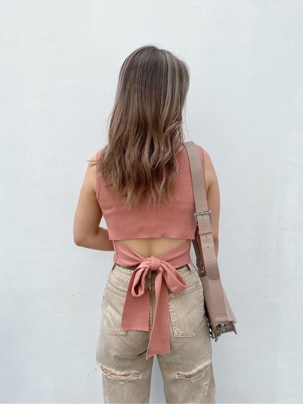 ベージュ系のデニムパンツ、ピンク系のタンクトップ、ホワイト系のサンダルを着用したレディースの夏コーディネートの2枚目の写真