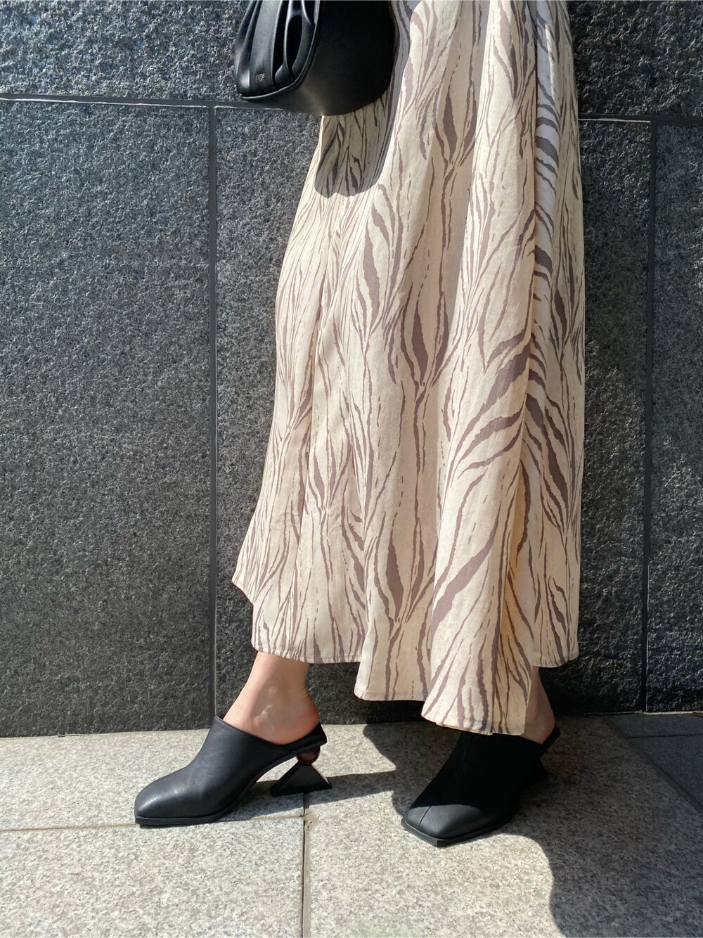 その他のワンピース、ブラック系のハンドバッグ、ブラック系のサンダルを着用したレディースの春コーディネートの4枚目の写真