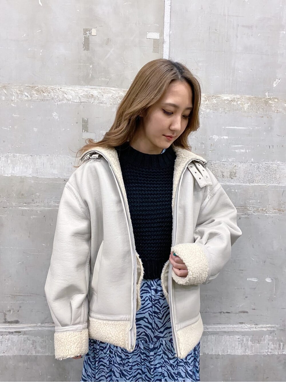 ブラック系のブーツ、ブルー系のワンピース、ホワイト系のブルゾンを着用したレディースの冬コーディネートの4枚目の写真