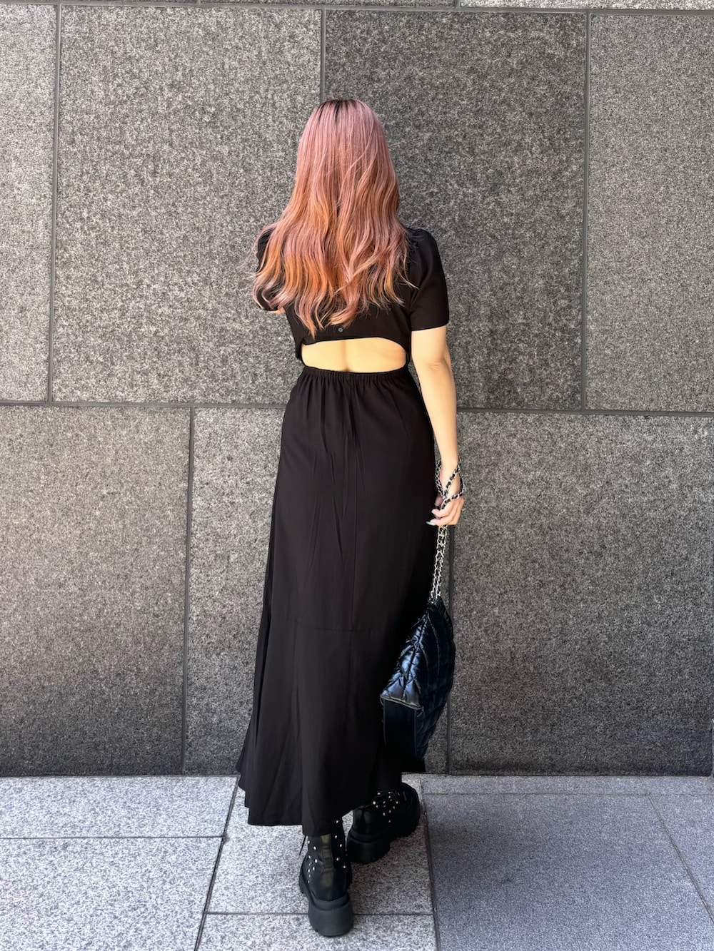 ブラック系のワンピース、ブラック系のショルダーバッグ、ブラック系のブーツを着用したレディースの春コーディネートの2枚目の写真