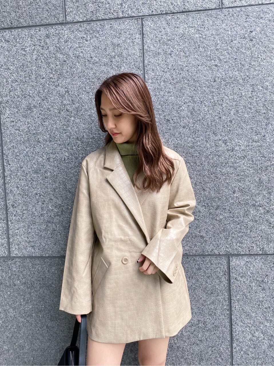 ブラック系のスカート、ブラック系のショルダーバッグ、ベージュ系のニット/セーターを着用したレディースの秋コーディネートの3枚目の写真