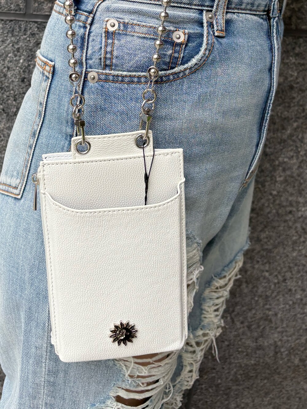 ピンク系のTシャツ/カットソー、ホワイト系のショルダーバッグ、ブルー系のデニムパンツを着用したレディースの春コーディネートの6枚目の写真