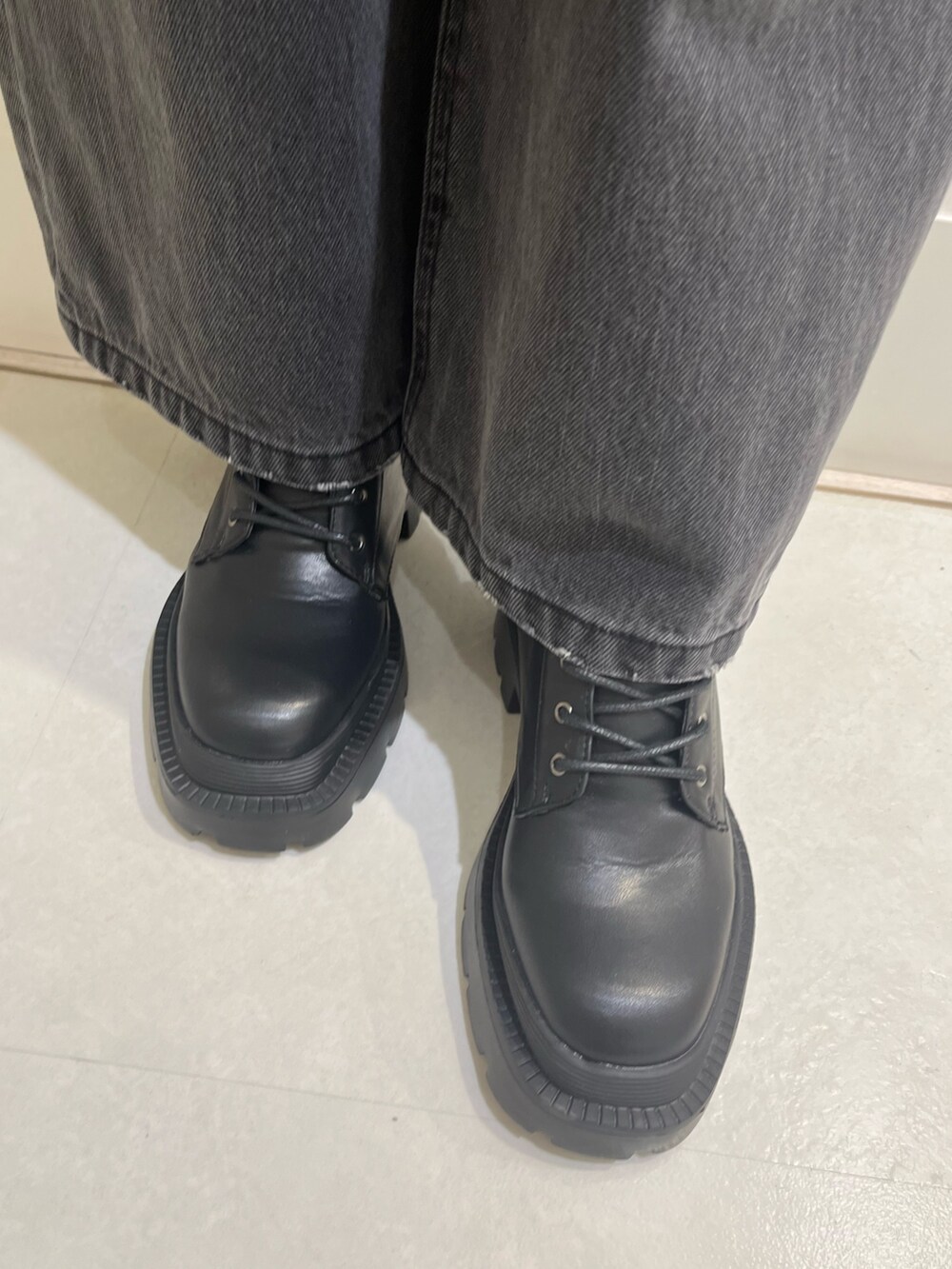 オレンジ系のカーディガン/ボレロ、ブラック系のデニムパンツ、ブラック系のショルダーバッグを着用したレディースの冬コーディネートの8枚目の写真