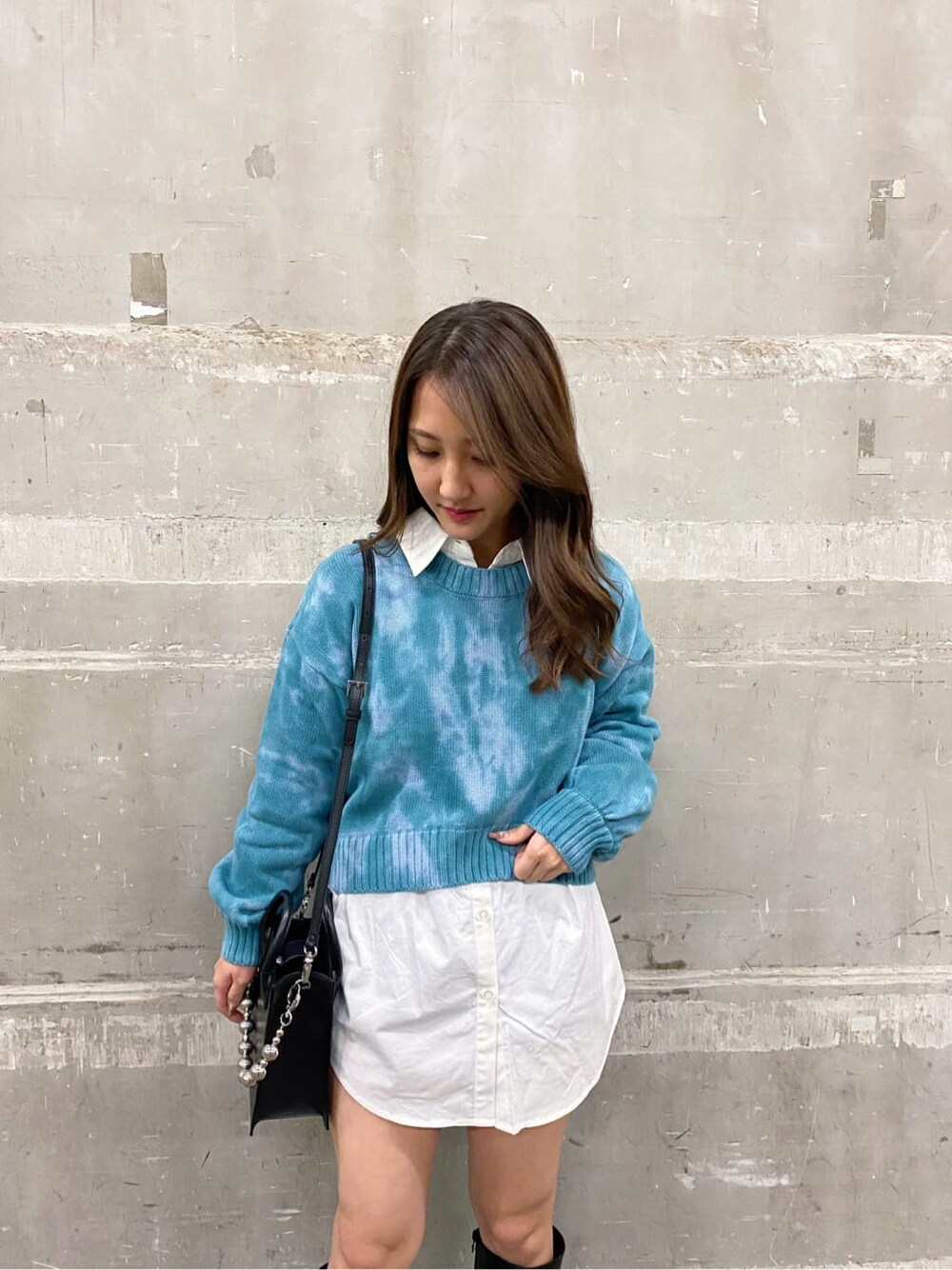 ブラック系のブーツ、ブルー系のニット/セーター、ホワイト系のシャツ/ブラウスを着用したレディースの秋コーディネートの3枚目の写真