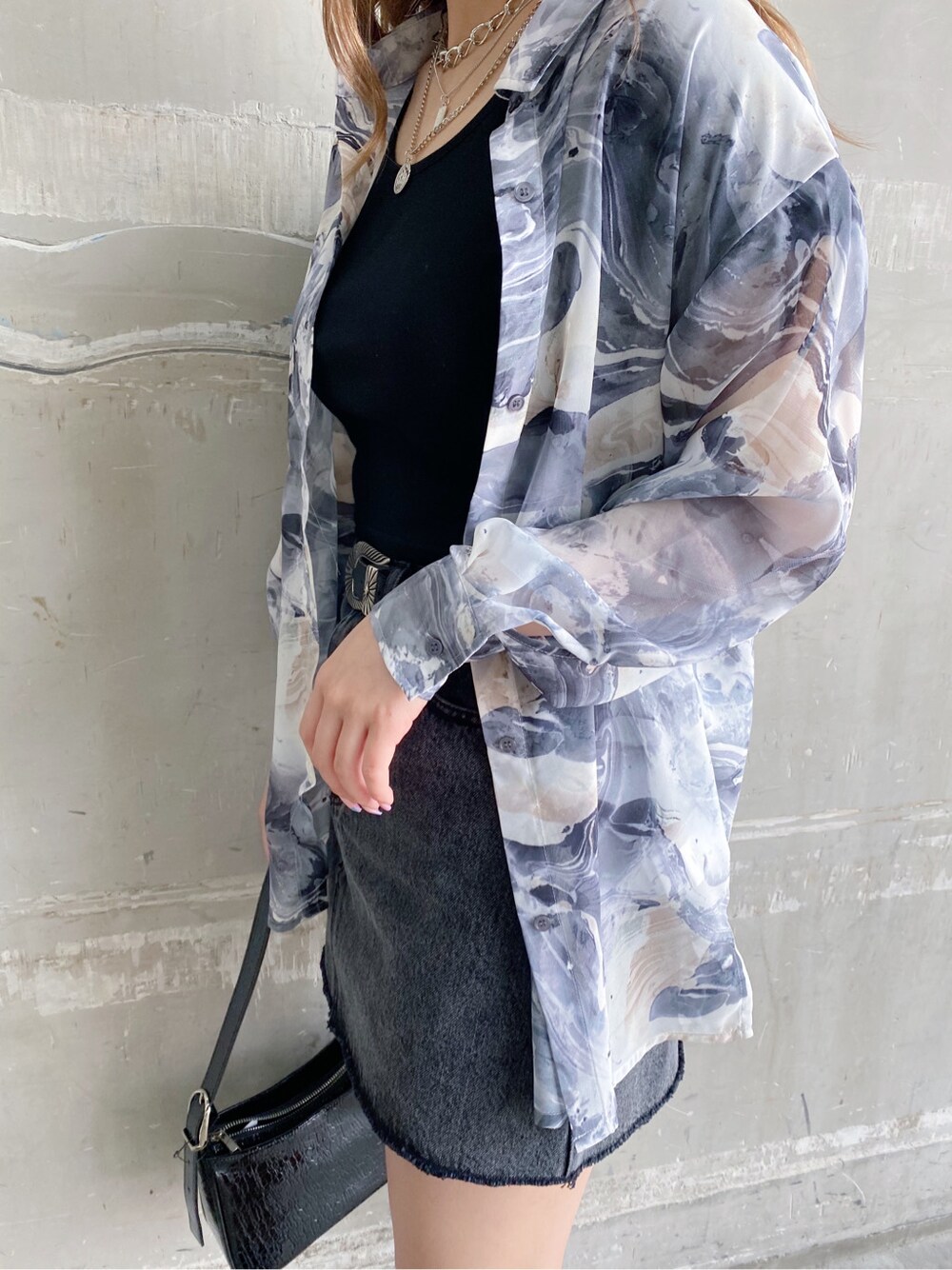 ブラック系のTシャツ/カットソー、ブラック系のデニムスカート、ブラック系のショルダーバッグを着用したレディースの春コーディネートの2枚目の写真