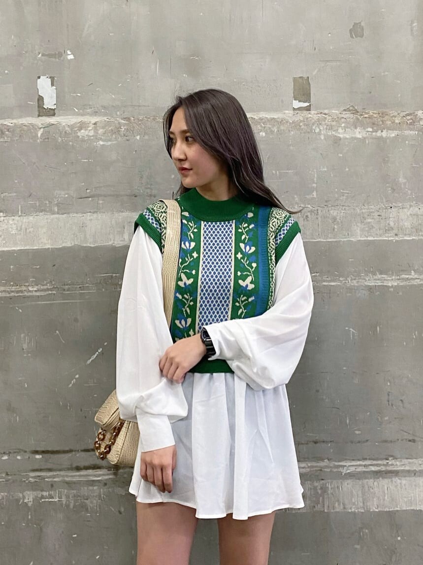 ホワイト系のショルダーバッグ、グリーン系のシャツ/ブラウス、ブラック系のブーツを着用したレディースの冬コーディネートの3枚目の写真