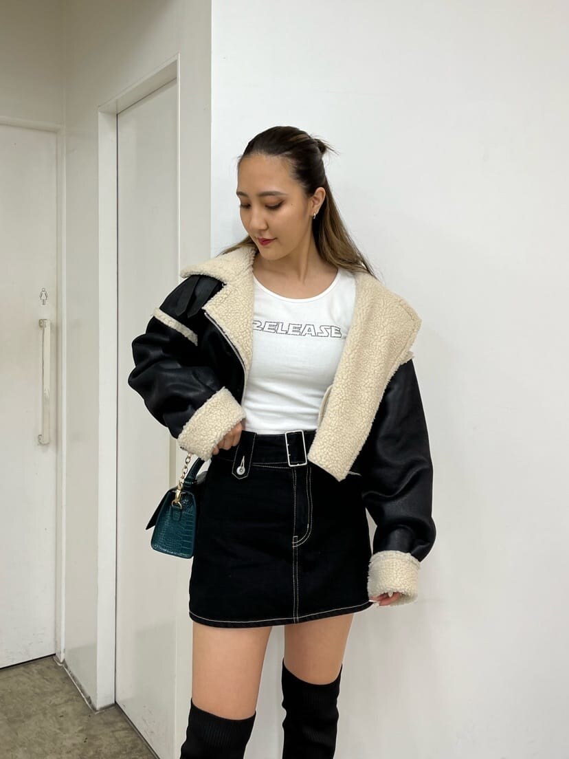 ブラック系のデニムスカート、ブラック系のブルゾン、ブラック系のブーツを着用したレディースの秋コーディネートの3枚目の写真