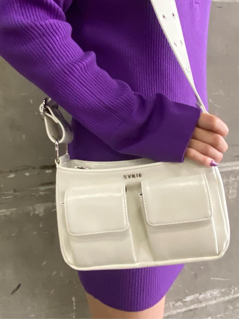 ホワイト系のショルダーバッグ、ブラック系のブーツ、パープル系のワンピースを着用したレディースの冬コーディネートの4枚目の写真