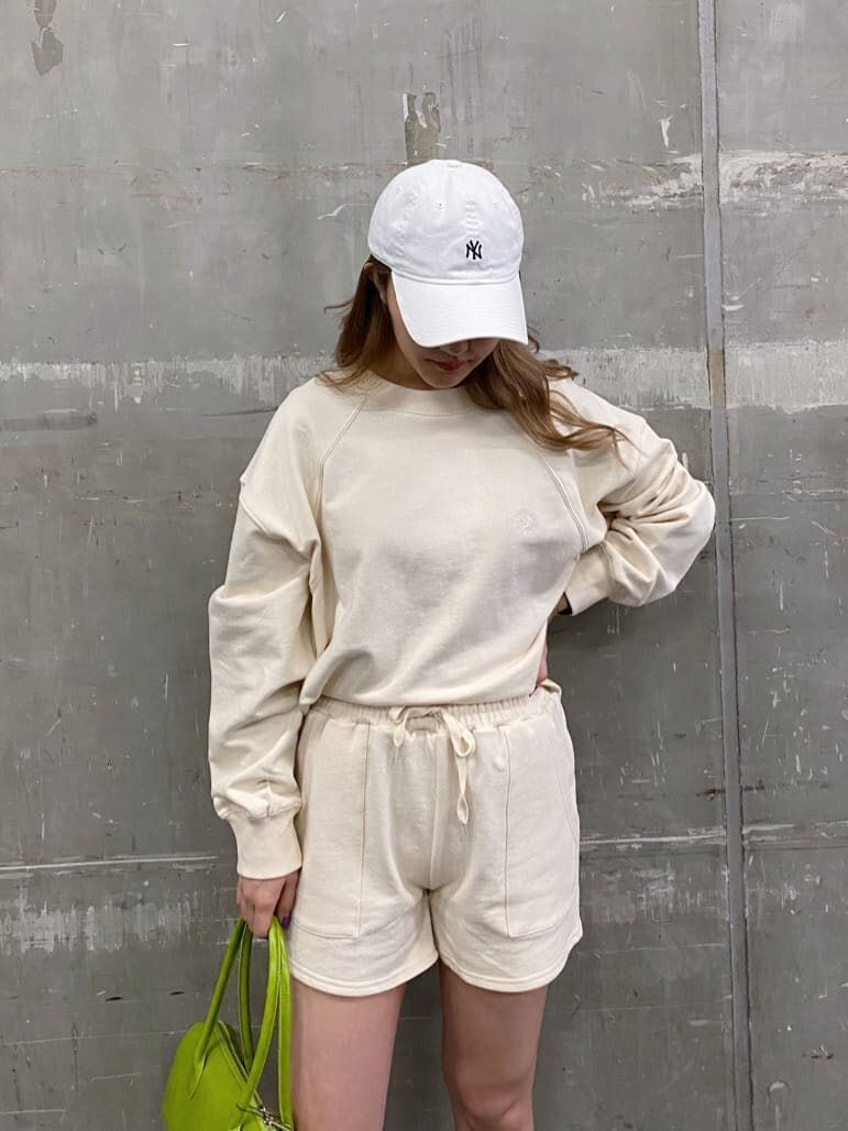 ブラック系のトレンチコート、グリーン系のボストンバッグ、ブラック系のブーツを着用したレディースの冬コーディネートの4枚目の写真